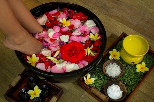 a person is standing in a bowl of flowers at PrimeBiz Hotel Kuta in Kuta