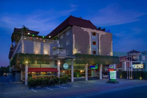 un edificio con plantas a su lado en PrimeBiz Hotel Kuta, en Kuta