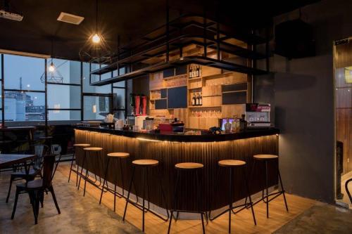 a bar with a row of stools in a restaurant at Odua Weston Jambi in Jambi