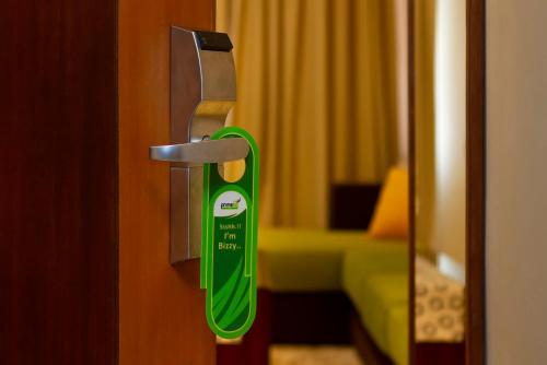 a green door handle in a hotel room at PrimeBiz Hotel Kuta in Kuta