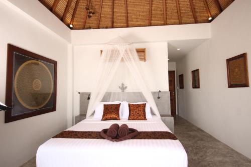a bedroom with a white bed with a mosquito net at Villas Sabai Jai in Koh Tao
