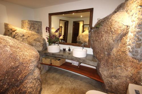 a bathroom with a sink and a large rock at Villas Sabai Jai in Koh Tao