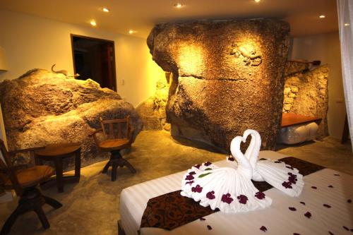 a room with a bed and a large rock at Villas Sabai Jai in Koh Tao