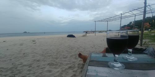 a glass of wine sitting on a table on the beach at Khao Tao Beach Lodge Old Siam in Hua Hin