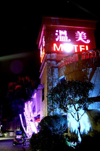 a building with a neon sign on the side of it at Wen Mei Motel in Nantou City