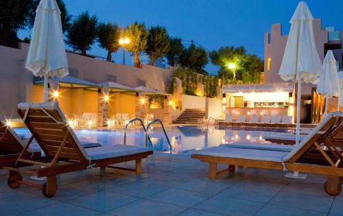 a swimming pool with two lounge chairs and umbrellas at Erytha Hotel & Resort Chios in Karfas