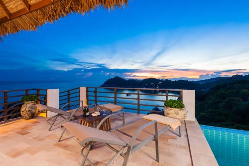 a patio with chairs and a table on a balcony at Villas Sabai Jai in Koh Tao