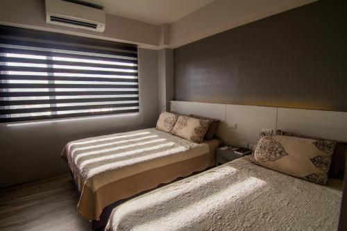 a bedroom with two beds and a window at Cebu Hotel Plus in Cebu City