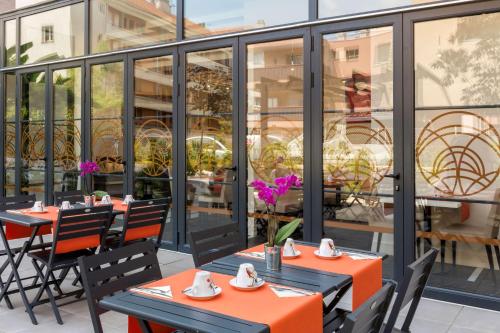 uma fila de mesas e cadeiras no pátio de um restaurante em Best Western Hôtel Journel Saint-Laurent-du-Var em Saint-Laurent-du-Var