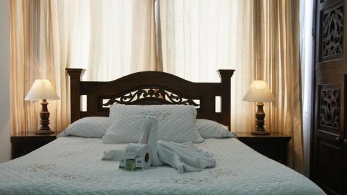 Una cama con toallas y un animal de peluche. en Hotel Sipa, en Duitama