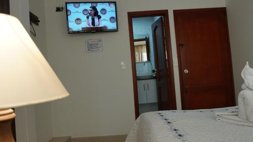 a bedroom with a bed and a tv on the wall at Hotel Sipa in Duitama