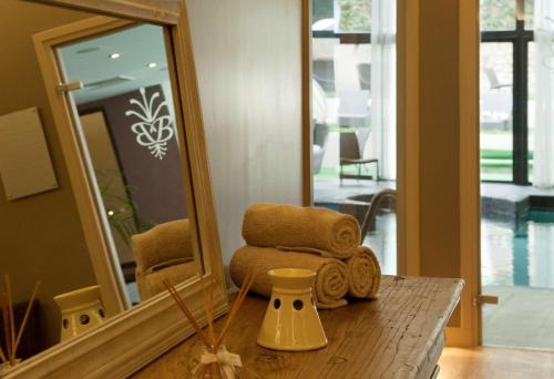 a mirror sitting on top of a table with towels at Hotel & Spa Le Grand Monarque, BW Premier Collection in Chartres