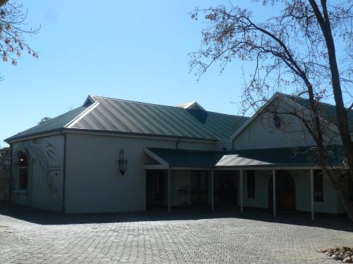 a large white building with a gambrel roof at Villa Jana Guesthouse in Pretoria