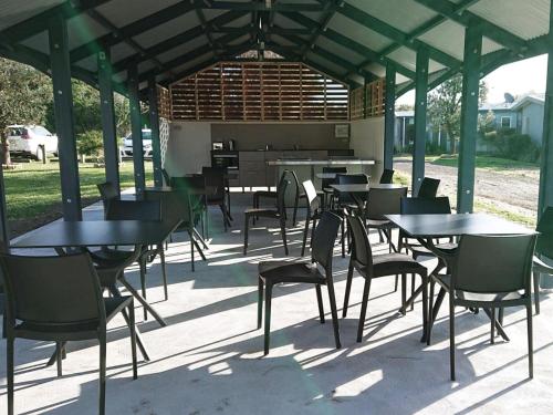 a patio area with tables, chairs and umbrellas at NRMA Port Campbell Holiday Park in Port Campbell