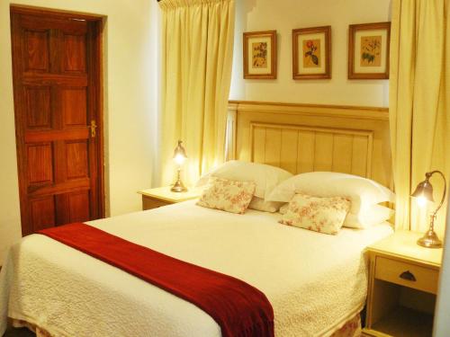 a bedroom with a large white bed with two pillows at Villa Jana Guesthouse in Pretoria