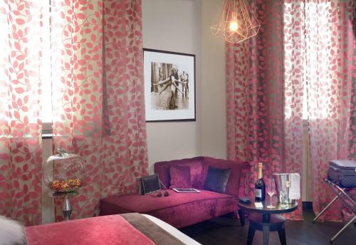 a living room with pink curtains and a pink chair at Best Western Plus Nice Cosy Hotel in Nice