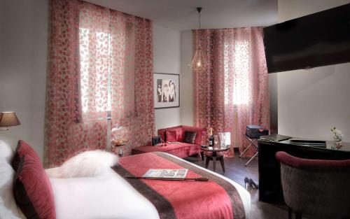a bedroom with red curtains and a bed and a desk at Best Western Plus Nice Cosy Hotel in Nice