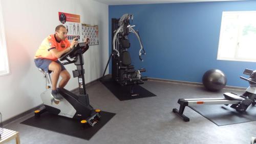 a man sitting on a exercise bike in a gym at Hôtel Saphir Lyon in Lyon