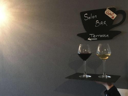 a person holding two glasses of wine on a shelf at Best Western Le Vinci Loire Valley in Amboise
