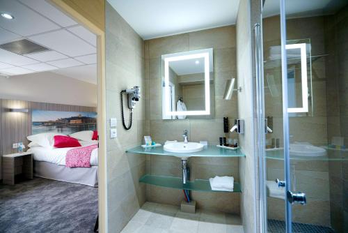 a bathroom with a sink and a shower and a bed at Hôtel Saphir Lyon in Lyon