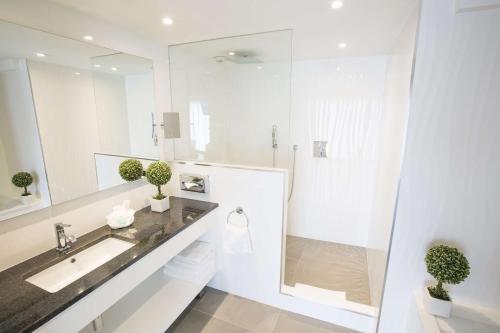 ein weißes Bad mit einem Waschbecken und einer Dusche in der Unterkunft Best Western Plus Cannes Riviera in Cannes