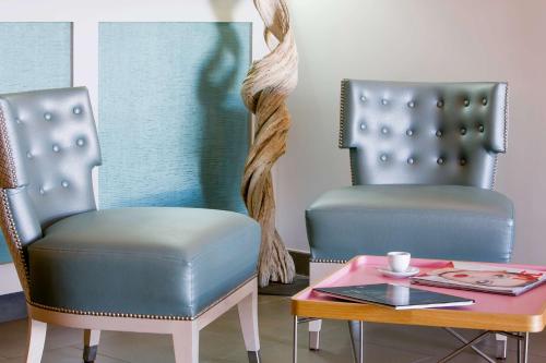 two chairs sitting next to a table with a coffeeucer at Best Western Hotel du Roy d'Aragon in Bonifacio
