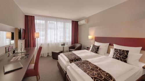 um quarto de hotel com uma cama grande e uma secretária em Best Western Hotel Darmstadt Mitte em Darmstadt