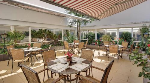 an outdoor patio with tables and chairs and windows at Best Western Hotel Darmstadt Mitte in Darmstadt