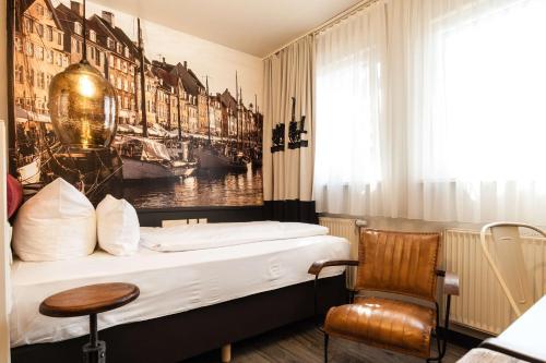 a hotel room with a bed and a chair at Best Western Hotel Nürnberg am Hauptbahnhof in Nürnberg