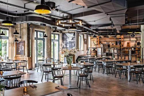 a restaurant with tables and chairs and windows at Best Western Plus Parkhotel Velbert in Velbert