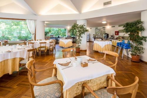 a dining room with white tables and chairs at Best Western Regina Elena in Santa Margherita Ligure