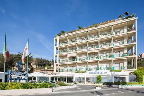 un hotel en la playa con banderas delante en Best Western Regina Elena en Santa Margherita Ligure