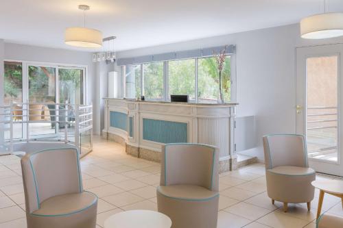 a living room with three chairs and a fireplace at Best Western Plus San Damianu in Sartène