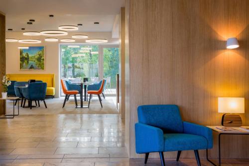 a waiting room with blue chairs and a table at Best Western Plus Hotel Divona Cahors in Cahors
