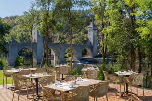 a restaurant with tables and chairs in front of a castle at Best Western Plus Hotel Divona Cahors in Cahors
