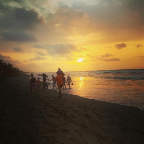 a group of people playing on the beach at sunset at Gran Muelle Hotel in San Bernardo del Viento