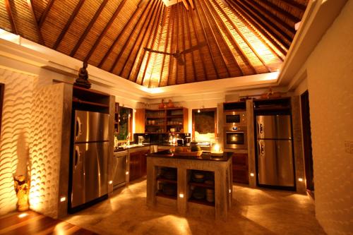 a large kitchen with a wooden ceiling and a refrigerator at Villas Sabai Jai in Koh Tao