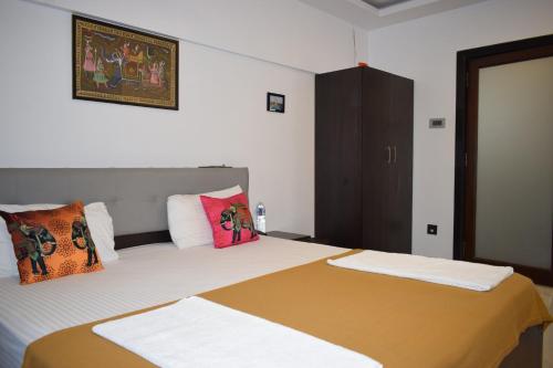 a bedroom with two beds with colorful pillows at Athi Resorts in Bogmolo