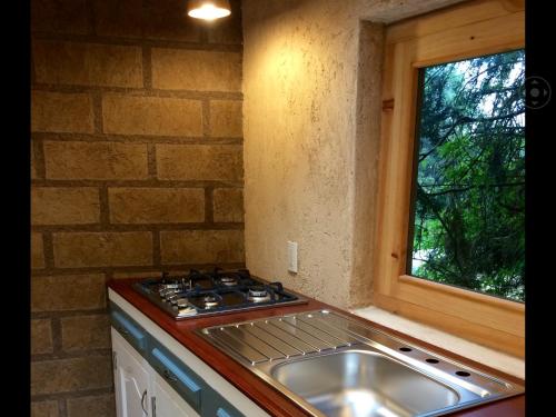 cocina con fogones, fregadero y ventana en La Montaña, en San Cristóbal de Las Casas