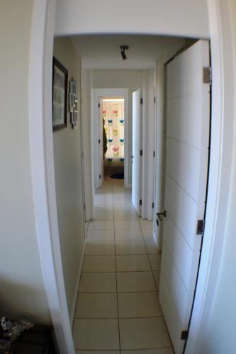 a hallway with white walls and white floors and a room at Apartamento Puerto Velero Tongoy in Puerto Velero