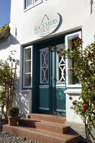 a front door of a house with a green door at Rackmers Hof - Suiten Hotel garni mit Sauna in Oevenum