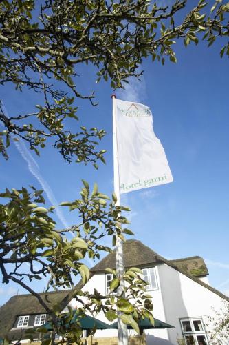 a white flag on top of a building at Rackmers Hof - Suiten Hotel garni mit Sauna in Oevenum