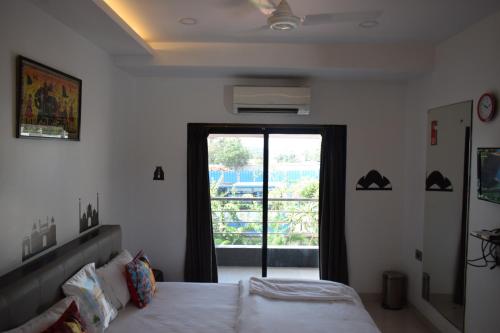 a bedroom with a bed and a large window at Athi Resorts in Bogmolo