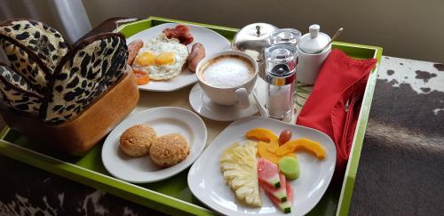 een groene dienblad met bordjes ontbijt en een vlinder bij Olarro Lodge in Maji Moto