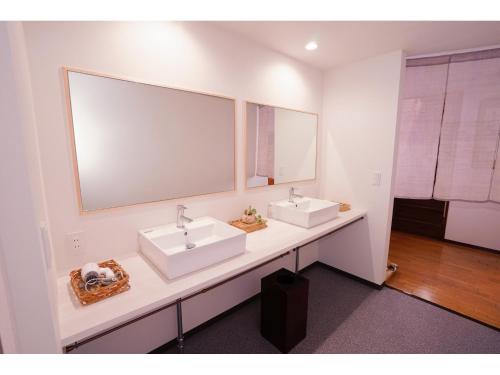 a bathroom with two sinks and a large mirror at Onsen Yado Mizuguchi in Izu
