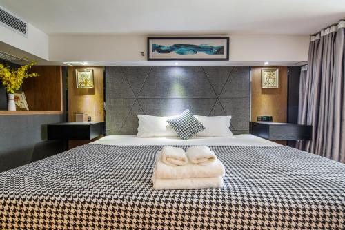 a bedroom with a bed with towels on it at Lavendar Duplex Apartment in Guangzhou