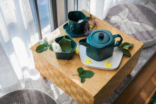 a table with a teapot and cups on it at Lavendar Duplex Apartment in Guangzhou
