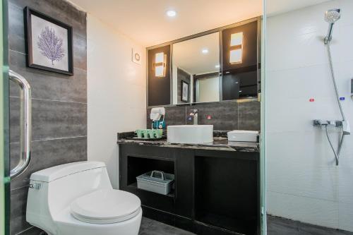a bathroom with a toilet and a sink and a shower at Lavendar Duplex Apartment in Guangzhou