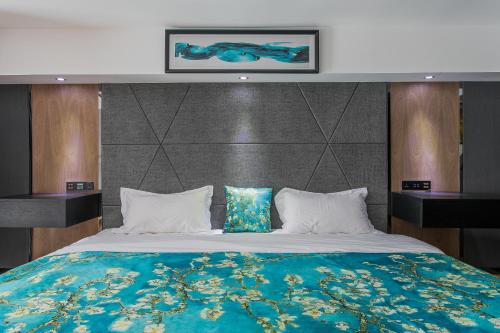 a bedroom with a large bed with a blue blanket at Lavendar Duplex Apartment in Guangzhou