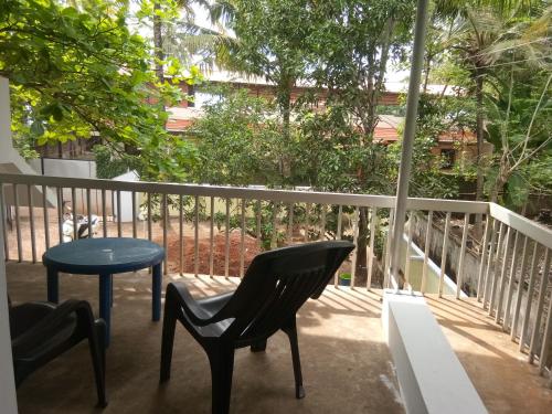 a patio with two chairs and a table on a balcony at Varkala Villa in Varkala